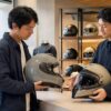 専門店で丸い帽体の高品質ヘルメットを比較する日本人ライダー