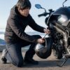 ツーリング先でバイクにヘルメットを固定する日本人ライダー