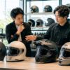 専門店で複数メーカーのバイクヘルメットを比較する日本人ライダー