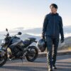 軽量バイクヘルメットを持ってツーリングへ出発する日本人ライダー