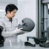 試験設備でバイクヘルメットの安全性を確認する日本人技術者