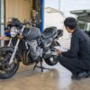 軽い損傷のあるバイクを安全な状態で査定する担当者と日本人オーナー