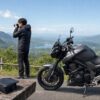 アクションカメラと写真用カメラを持って景色を撮影するライダー