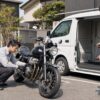 大手出張買取を想定した無地車両のそばでバイク査定を受ける日本人オーナー