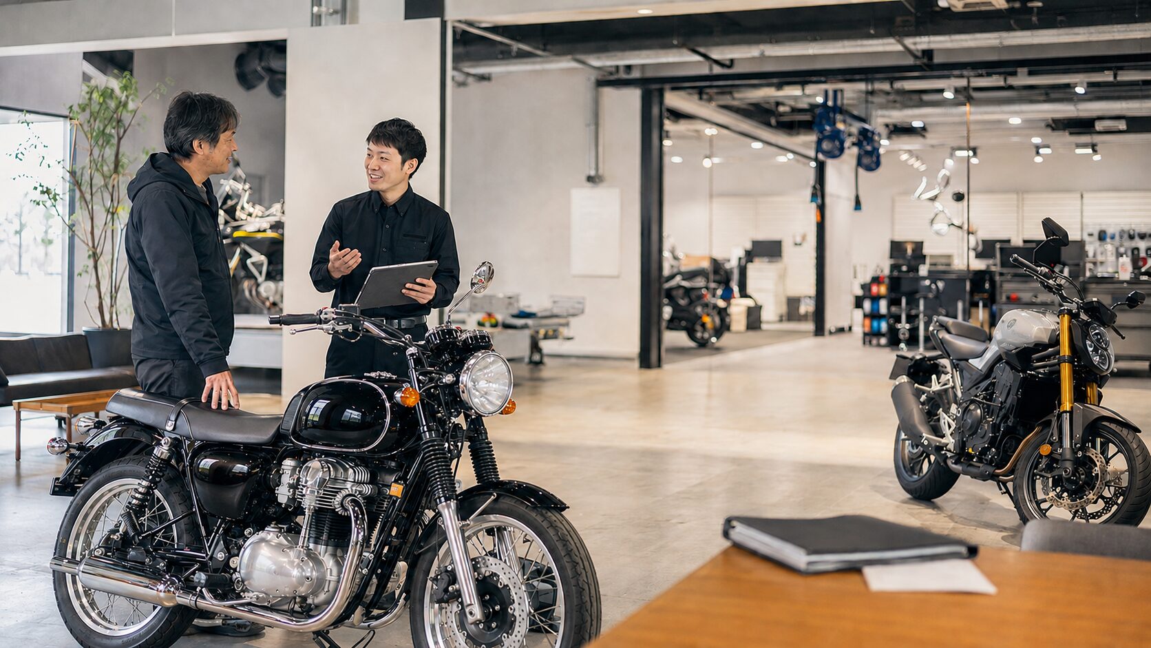 大型バイク販売店で愛車の買取と買い替えを相談する日本人オーナー